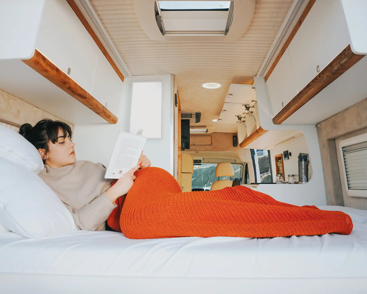 Kiasa Infrared Heater - 180w Low Wattage Heating for Motorhomes - Heater is wall amounted in small wall while lady reading in front