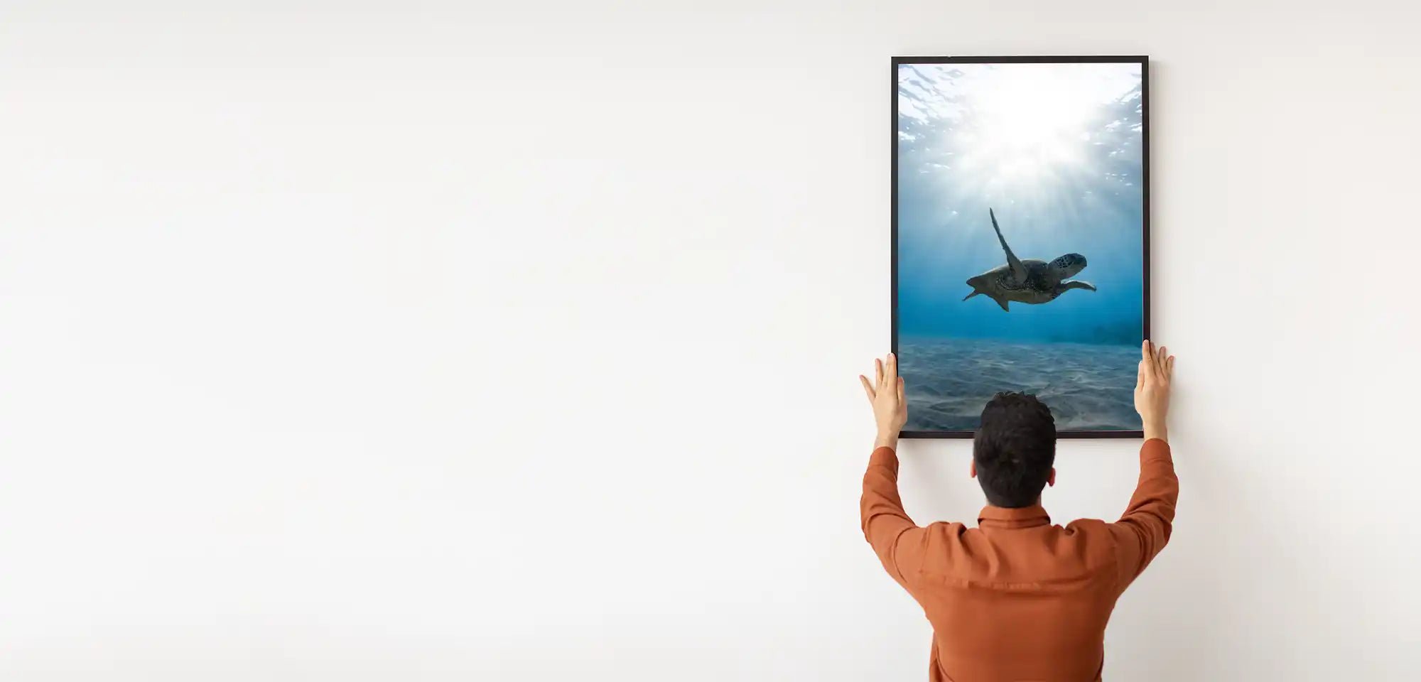 Kiasa infrared heating - large collection of IR picture panels - Man mounting IR panel of Turtle on the wall