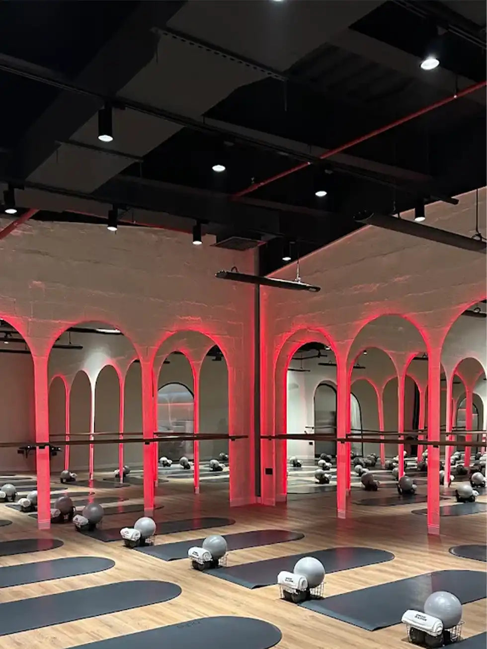 Gym interior with arches and exercise equipment under red lighting With Kiasa Premium Ikon Bars suspended down from ceilings
