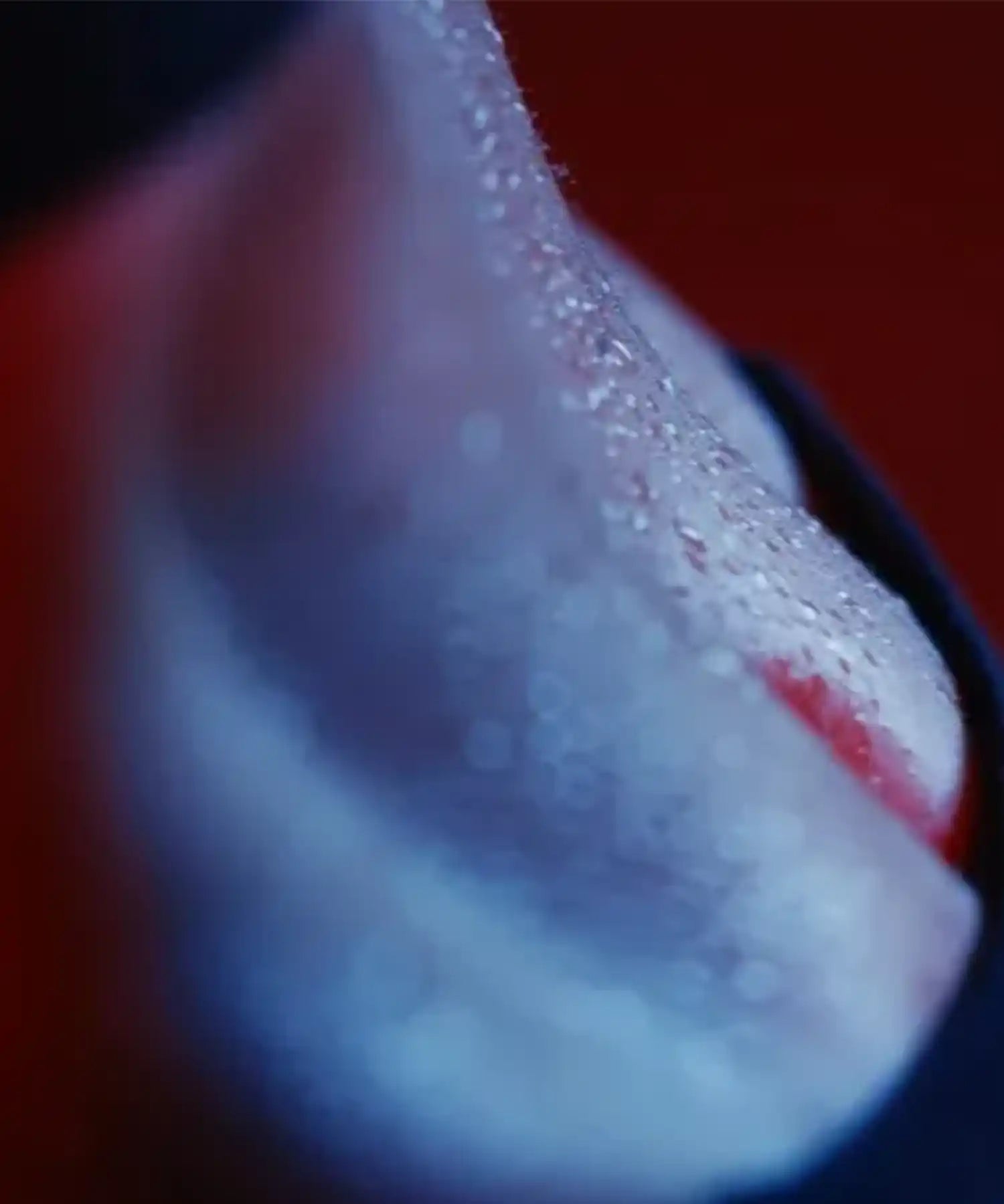 Close-up of sweat on participant’s skin in a hot Pilates class at YOURS Studio London, red ambient lighting and blurred background
