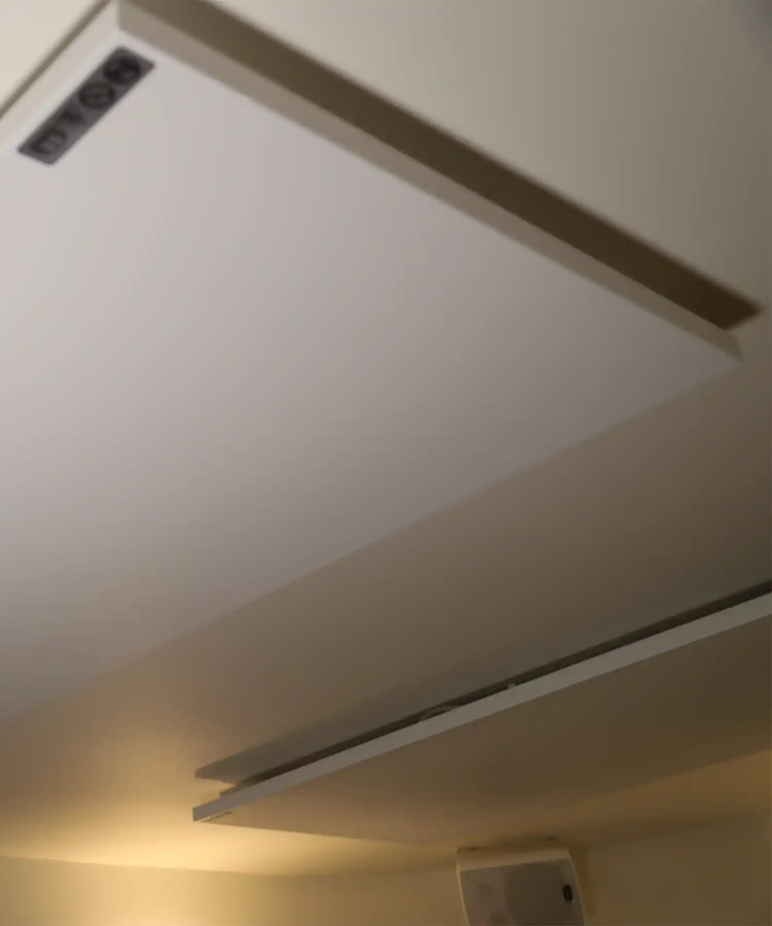 Close-up of ceiling-mounted infrared heating panels inside Reformer Revolution’s studio, showing the slim, minimalist design integrated into the ceiling.
