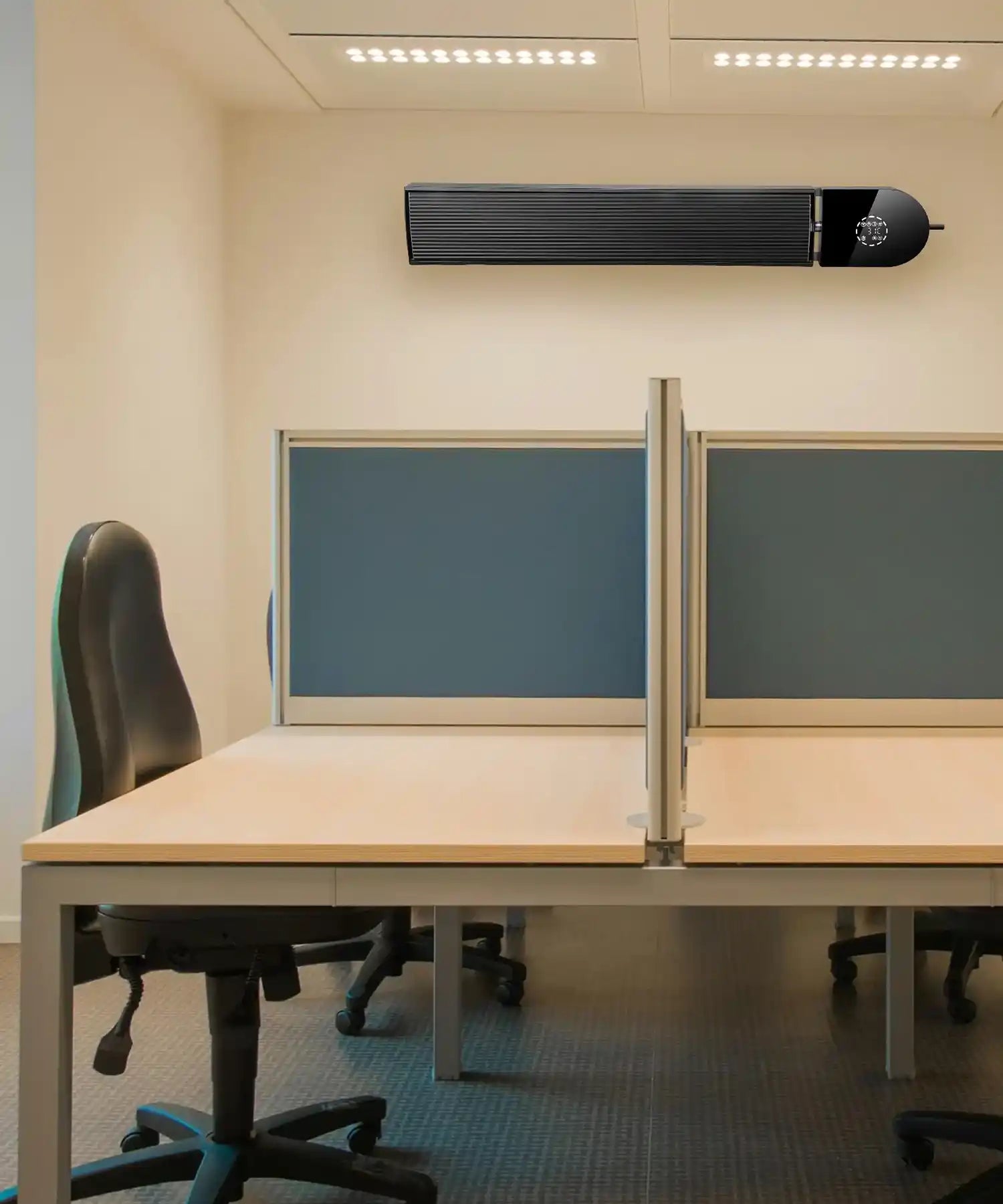 Black KIASA heater bar mounted on the wall above an open-plan office cubicle setup with modern blue partition panels.