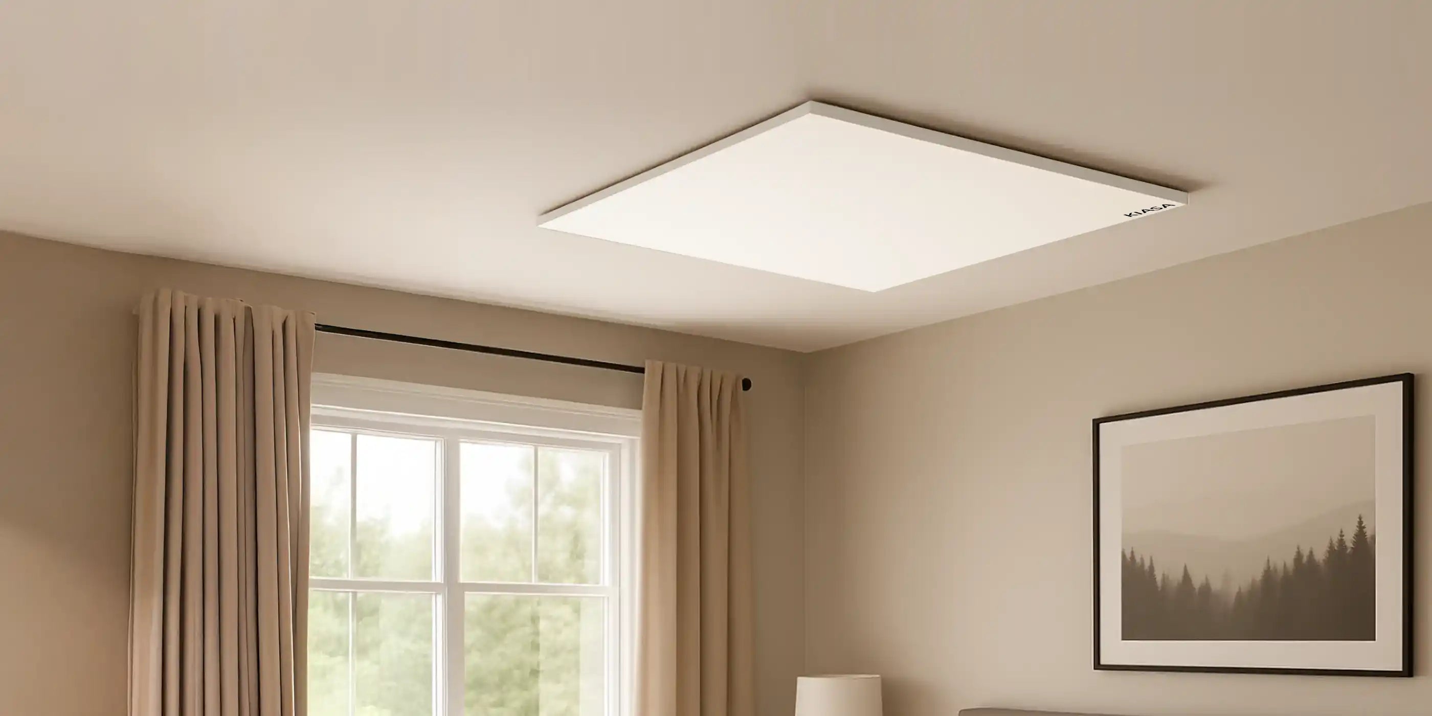 Ceiling-mounted Kiasa Kore infrared panel heater in a minimalist bedroom with neutral tones, soft lighting, and framed wall art above the bed.