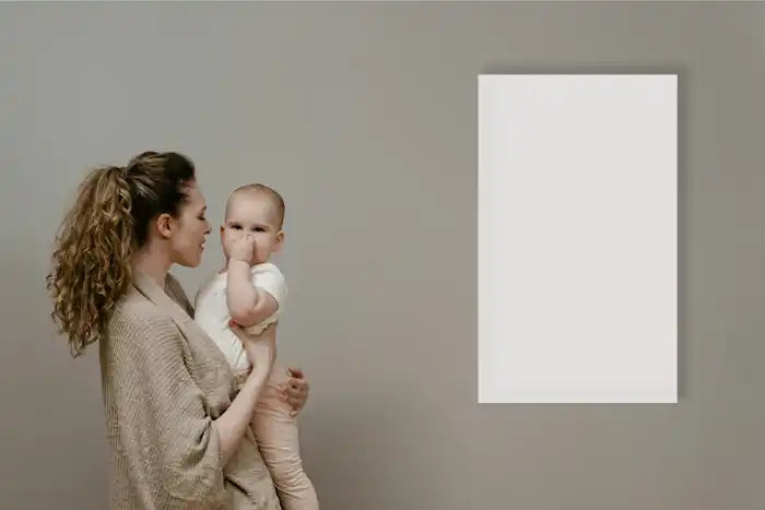 A mother with baby informt of IR heat panel