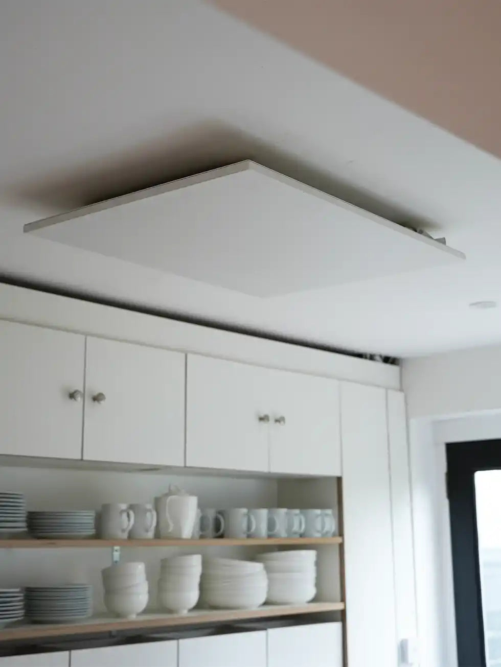 Ceiling-mounted infrared heating panel installed in a modern kitchen for silent, energy-efficient warmth