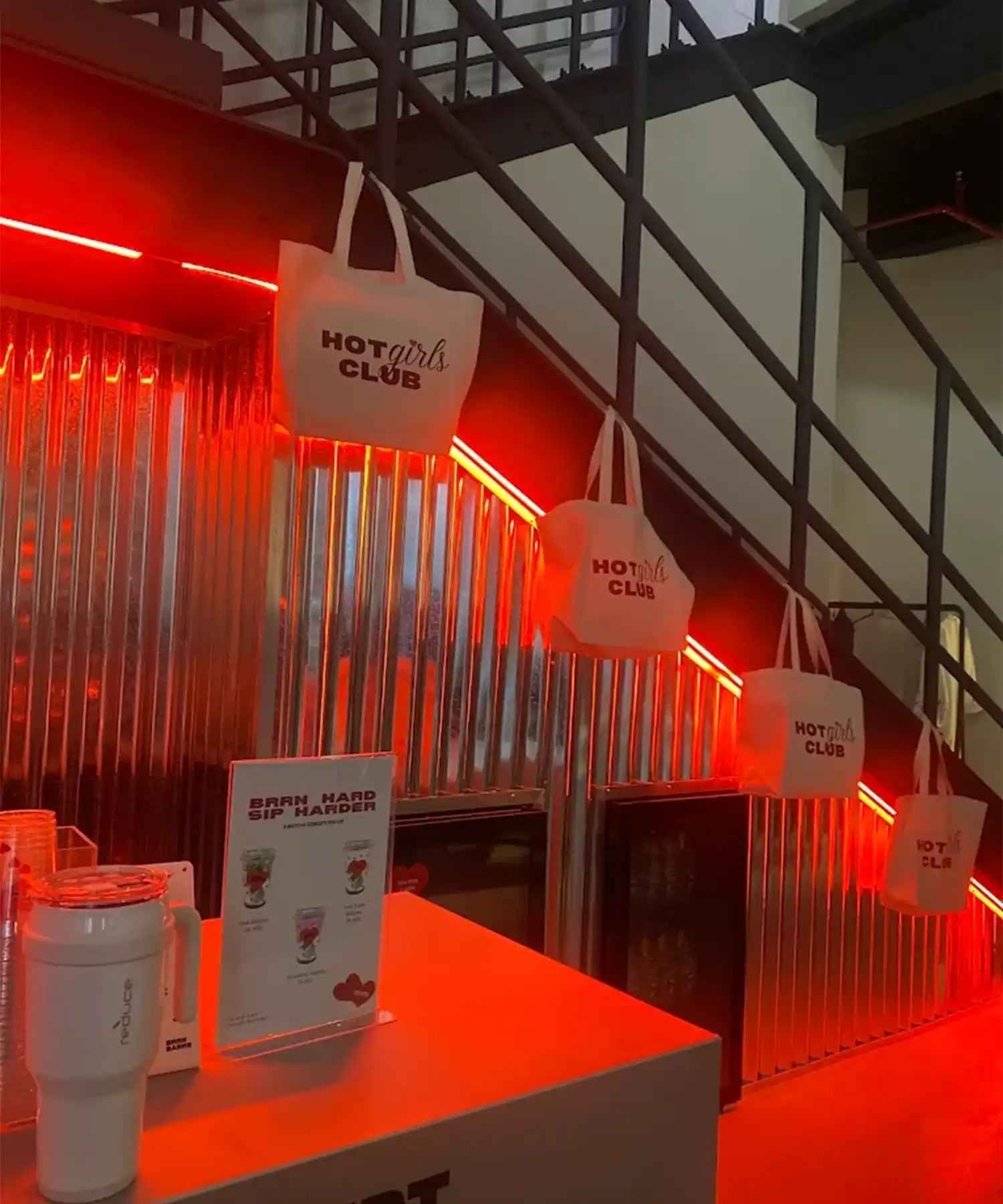 Reception/lounge area of BRRN BARRE Dubai with red accent lighting and UK-supplied infrared heater bar positioned above, creating a stylish warm environment.