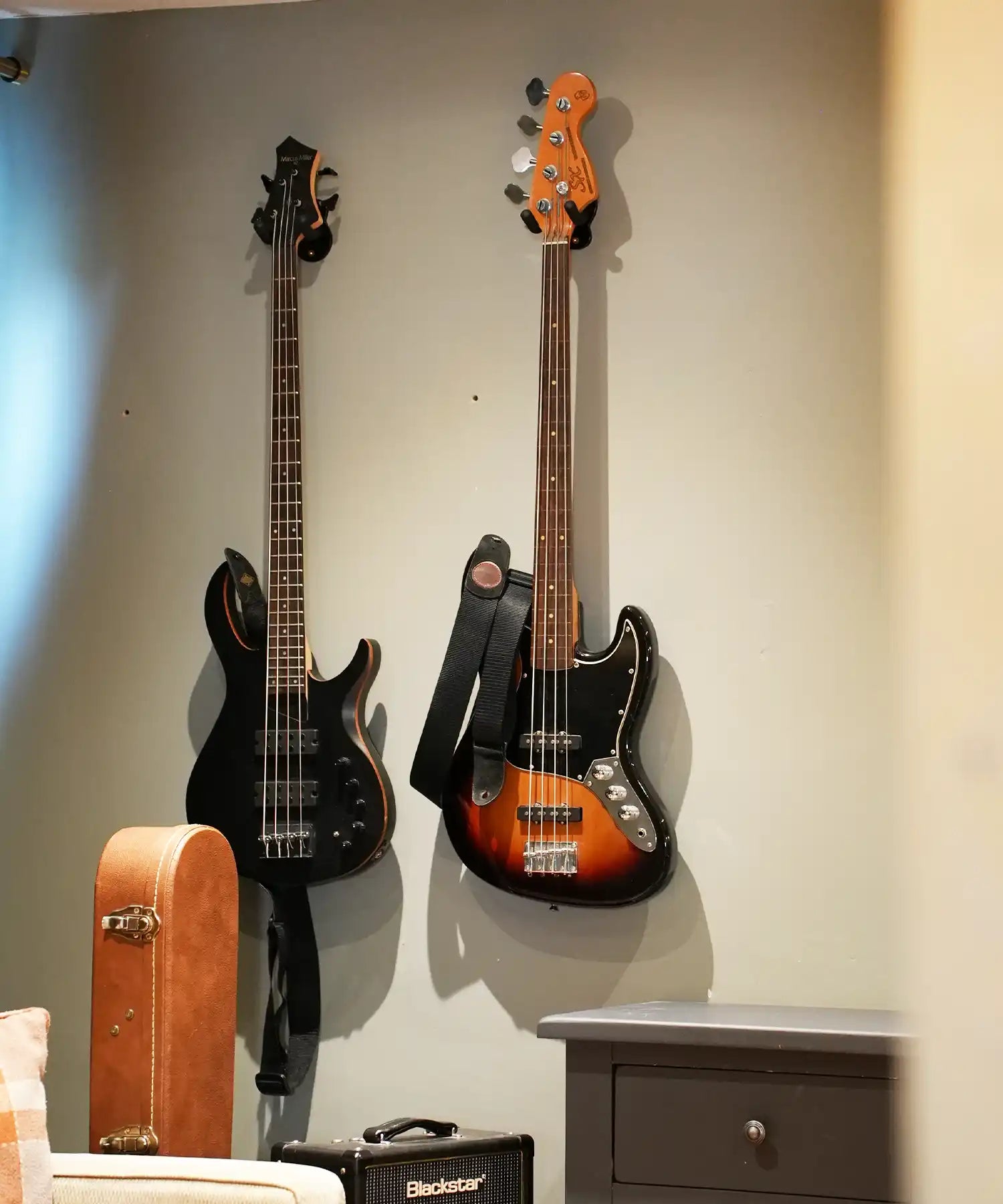 Wall-mounted electric bass guitars in an independent recording studio with silent infrared heating for music rooms