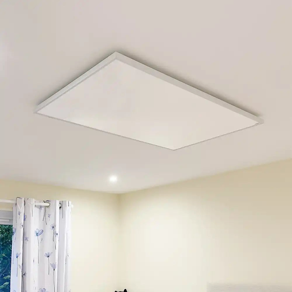 Kiasa Classic infrared heating panel installed flush on a white ceiling in a softly lit room with cream walls and floral curtains.
