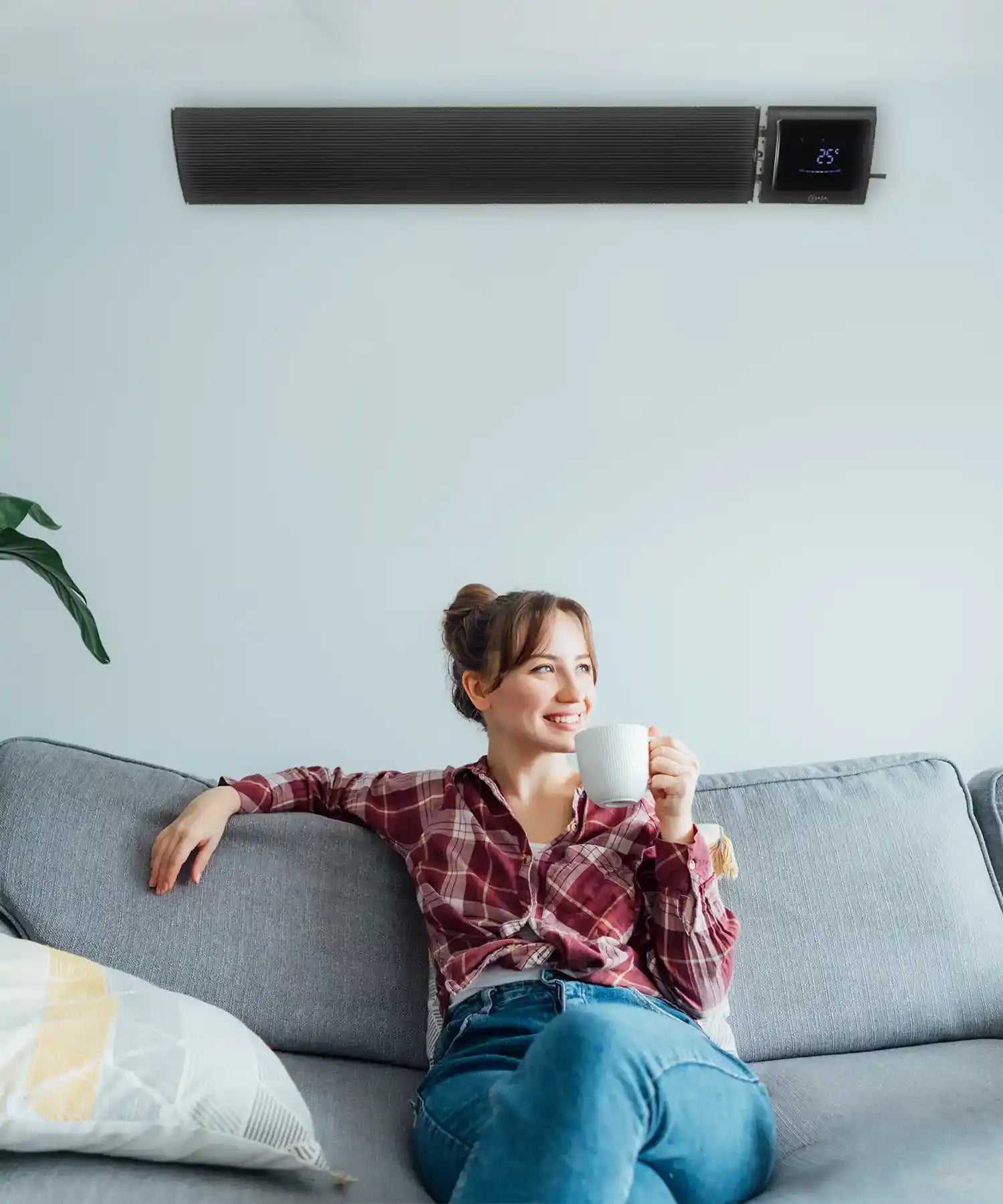 Modern living room with IKON infrared heater bar mounted on the wall above a sofa providing radiant heating.