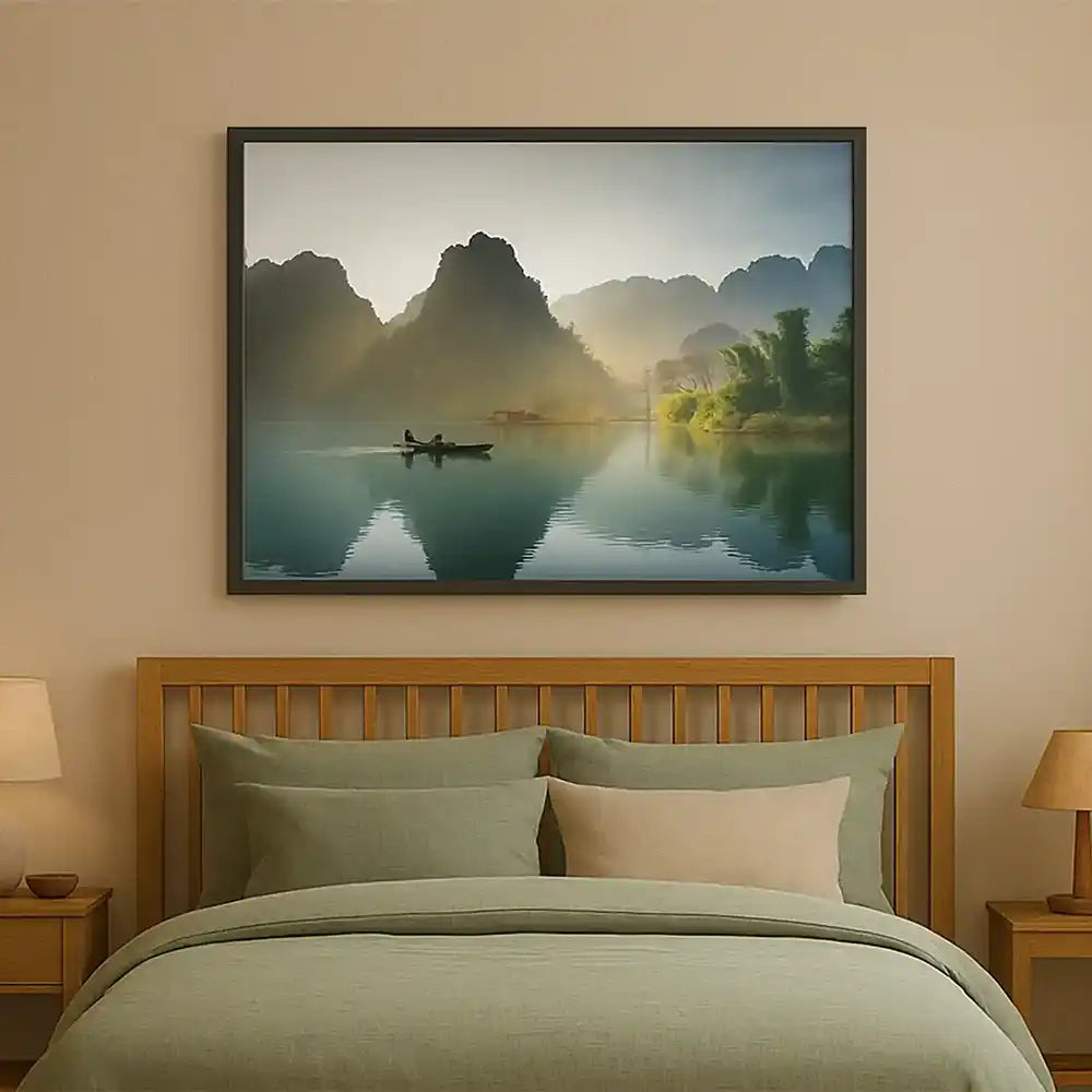 Infrared heater disguised as a tranquil lake and mountain landscape photo, mounted above a bed in a warm, earthy bedroom setting
