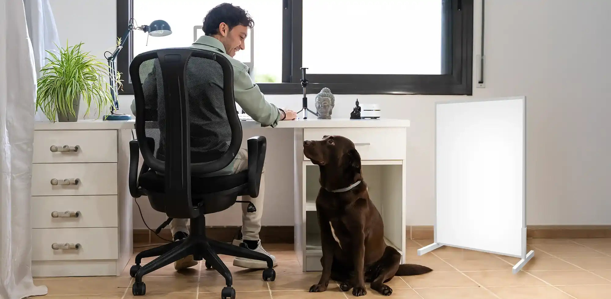 Man working in office using 600w panel heater at home with his pet dog safely